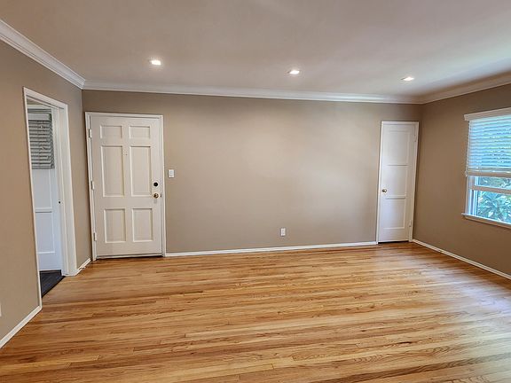 LIVING ROOM WITH CROWN MOLDING AND CAN LIGHTING. REFINISHED HARDWOOD FLOORS.