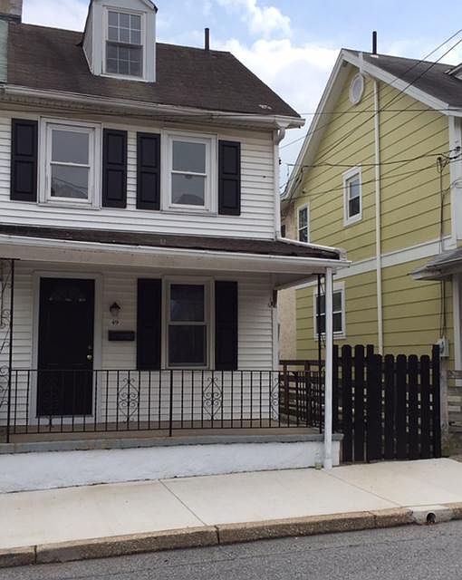 Twin home with front porch and fenced yard.