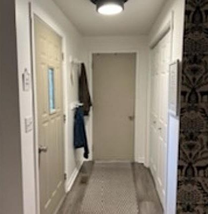 Entryway. Front door on left, and garage access door straight ahead. Pantry doors on right.