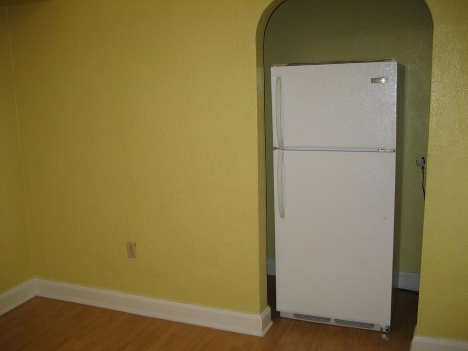 Refrigerator sets back in alcove. Laminate flooring in kitc