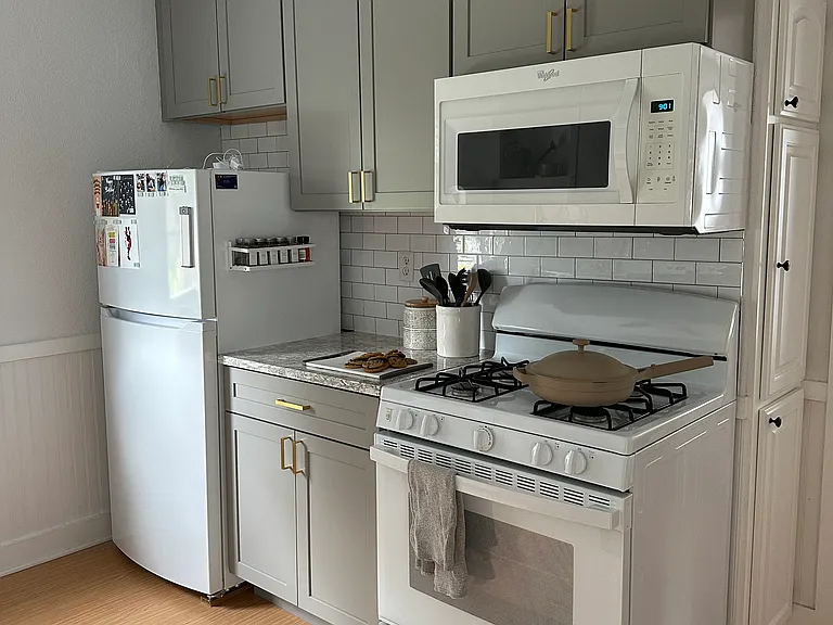 There's a full size range and microwave, and an apartment size fridge (new in 2025). The room has a ceiling fan for comfort.