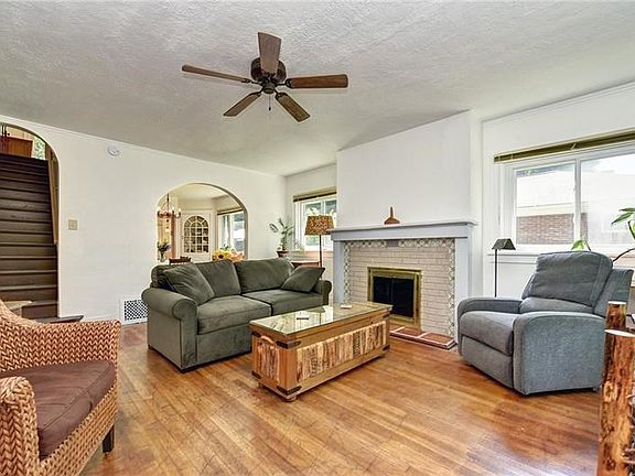 Hardwood floors, arched doorways and neutral tones, with a unique ceramic tile fireplace.