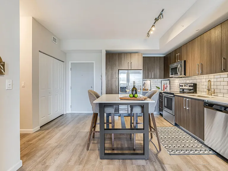 Full Kitchen with Dining Island, Stainless Steel Appliances, and Tile Backsplash
