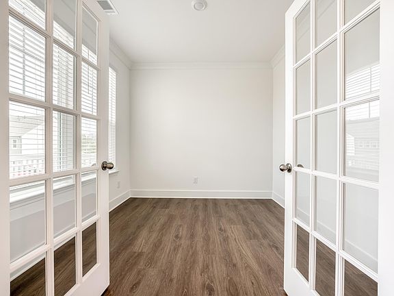 Convenient flex space on the first floor features double doors and can work well as a home office, book nook, or additional living area.
