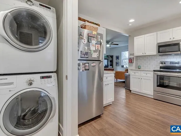 Stackable washer and dryer hidden behind door.