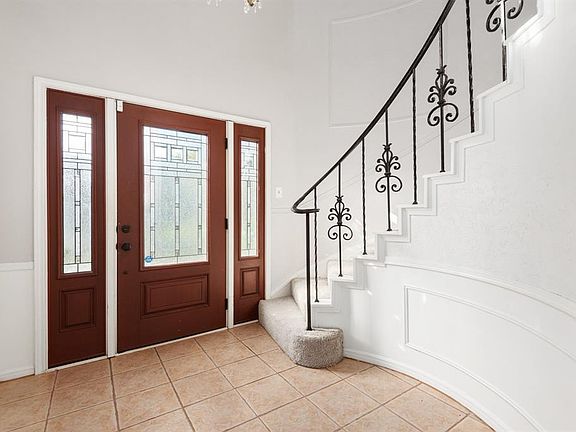 Greet your guests in this two story foyer with spiral staircase, iron balusters and updated front door and sidelights.