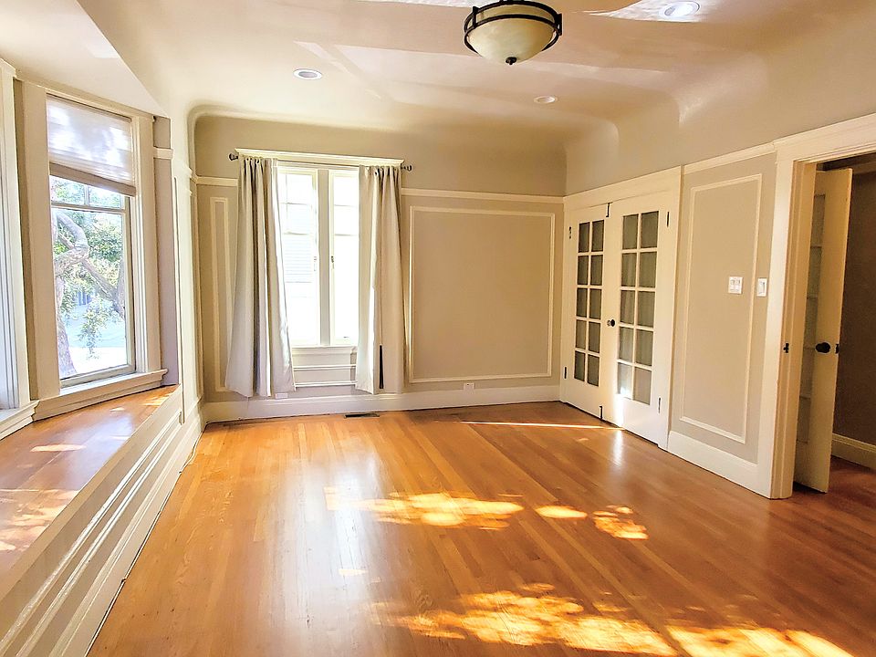 Living room w/ tons of sunlight. Bay windows w/ window seat look out onto peaceful Lake St. (Slow Street) below