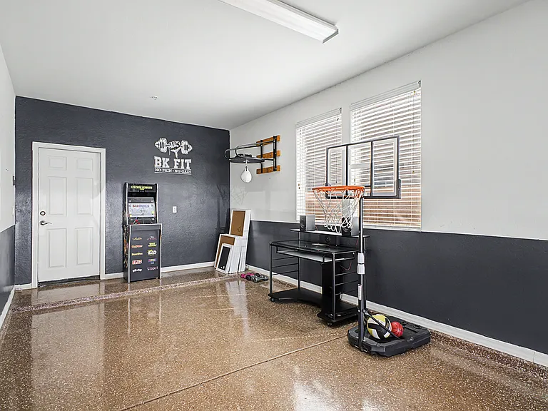 The tandem three car garage is in excellent condition and features durable epoxy flooring, a built in water softener, a dedicated storage area, and gardening tools for added convenience.