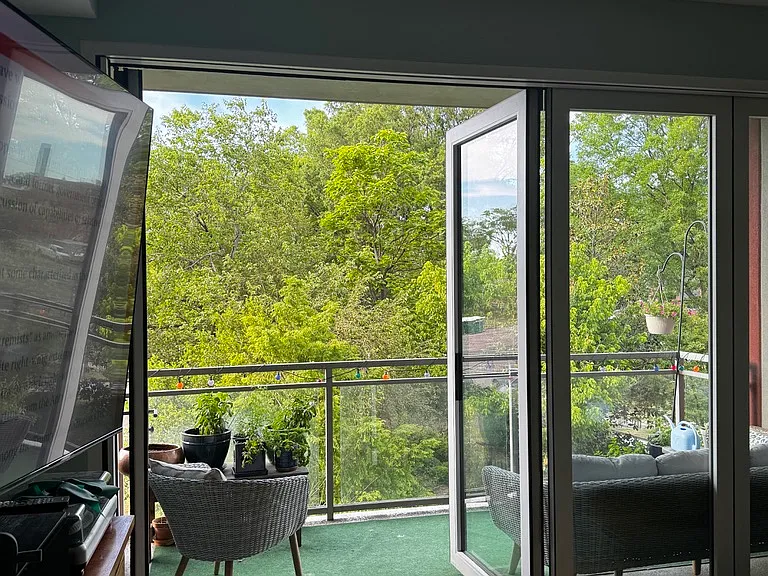 view onto deck/balcony with 1/2 of door open.