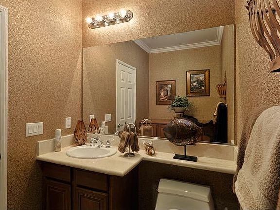 Powder Room with Slab Crema Marfil Countertop, and Cork Wallpaper.