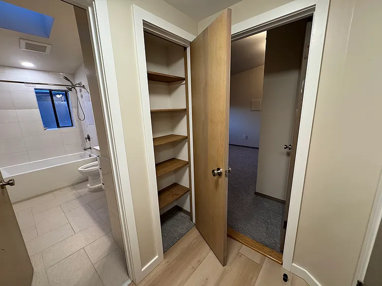 Bathroom, linen closet and primary bedroom
