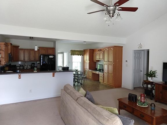 The view when you walk in the front door. See the bar/kitchen in the back left, the dining area and ample storage on the back center, and the living area in the front.