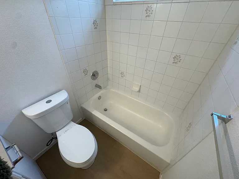 Bright full bathroom featuring a tub/shower combination and clean, easy-to-maintain finishes.
