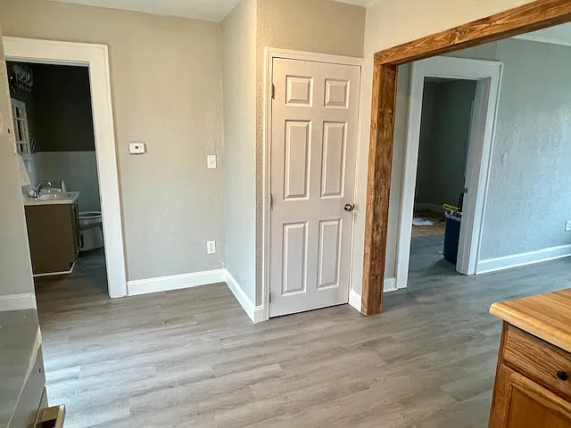 bathroom all the way to the left, basement door in the middle, bedroom door off living room all the way to the right