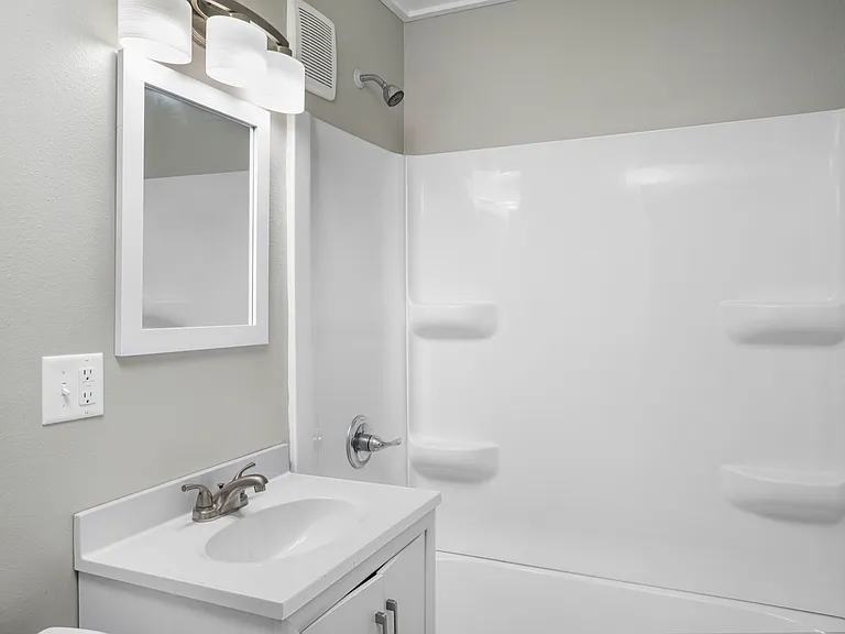 Modern bathroom with sleek white vanity, elegant mirror, and clean shower space. Modern bathroom with sleek white vanity, elegant mirror, and clean shower space.