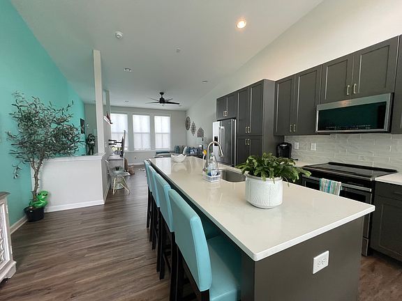 Kitchen features quartz countertops, breakfast bar which seats 4, stainless steel appliances including Bosch refrigerator.