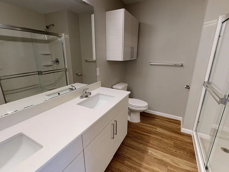 The Walnut's primary bathroom includes a double sink, quartz vanity, and walk-in shower. The Walnut's primary bathroom includes a double sink, quartz vanity, and walk-in shower.