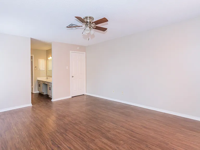 Huge beautiful master bedroom to our Townhome showing a glimps of the vanity goint to private restroom
