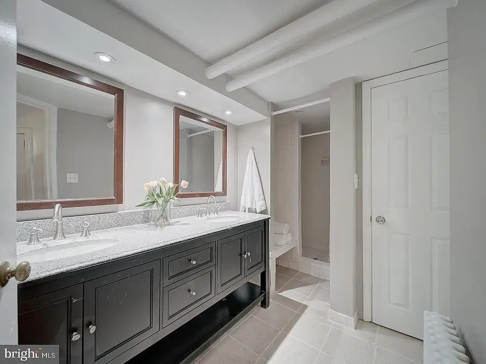 Bathroom is a dorm style bathroom, featuring double sinks, two separate shower stalls, and two separated water closets with lockable doors.