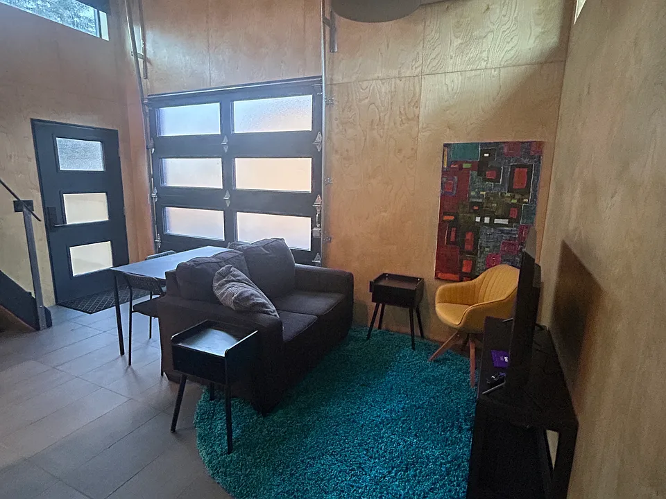 Living area with full slide up door which opens to the alley.