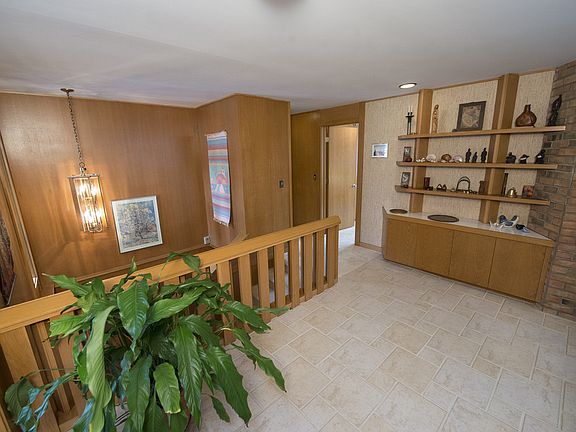 Welcome home! The tiled front entry is the heart of this wonderful home. Gorgeous and well-maintained mid-century oak lines the walls and the banister of the lower level landing.