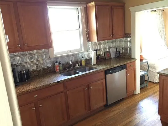 Another view of kitchen. Plenty of counter tops Metal tiles on backsplash also on ceiling.