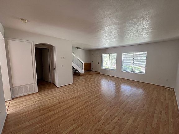 Living room looking at front door, 1/2 bath + utility closet.