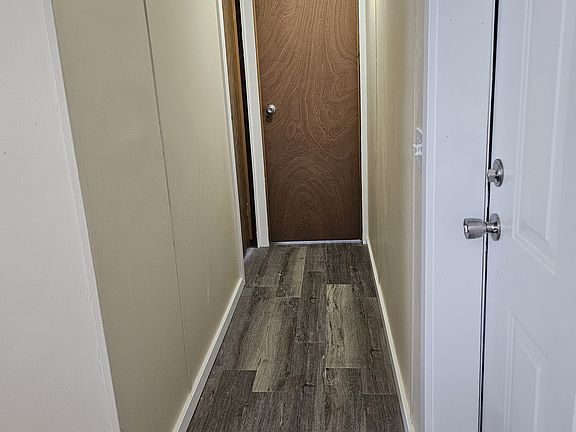 Hallway that leads to the right of the front door that has (2) bedrooms off of it.