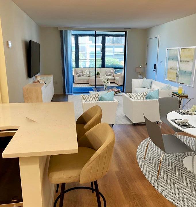 Kitchen/family room open concept to the eat in island with quartz countertops. Diving room accent wall is shiplap.