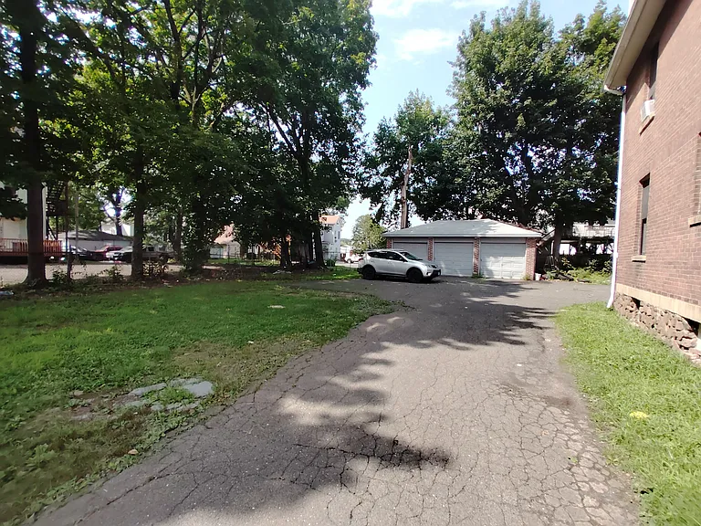 Driveway, parking area, and left side yard.