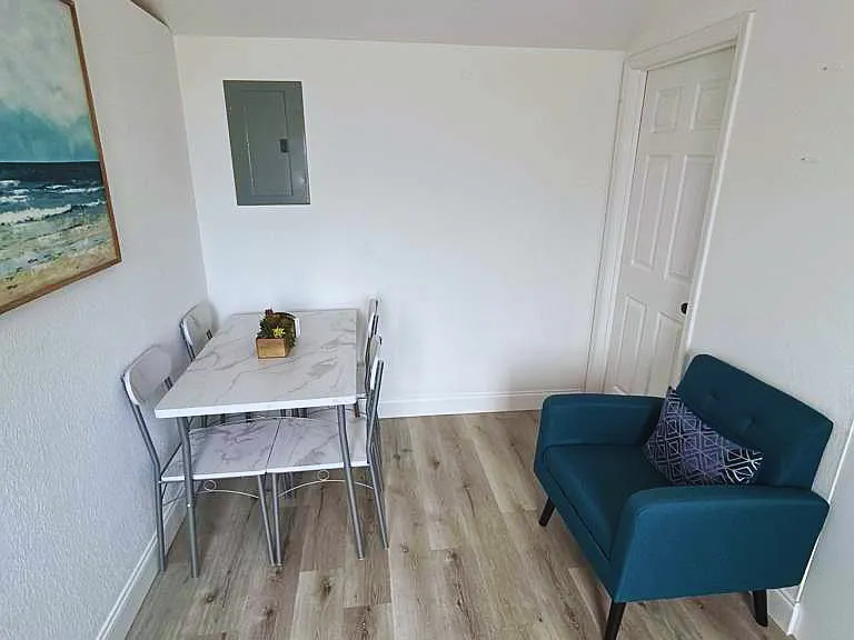 Comfortable dining area with 4 chairs, accent chair, and wall art