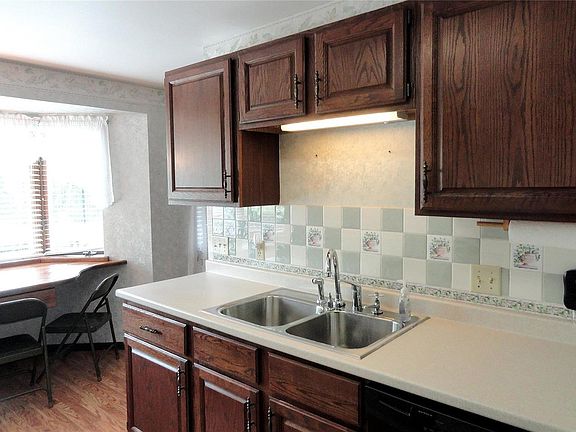 Galley kitchen with eat-in counter looking out the front of home.