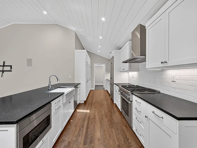Upgraded Thermador appliances in kitchen with gobs of storae in the cabinets on left and right just past the fridge.