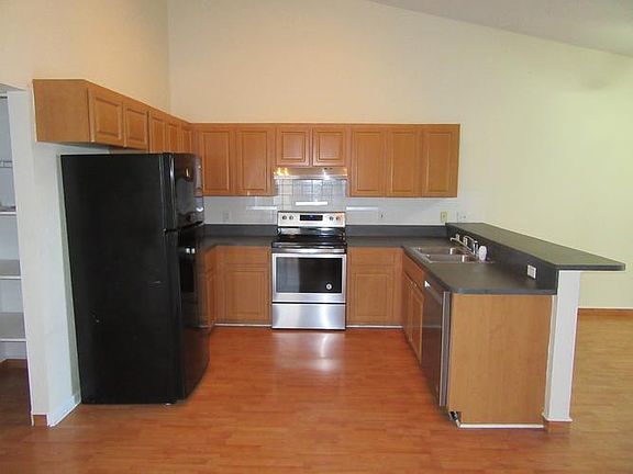 Kitchen with soaring ceilings and new stove, dishw