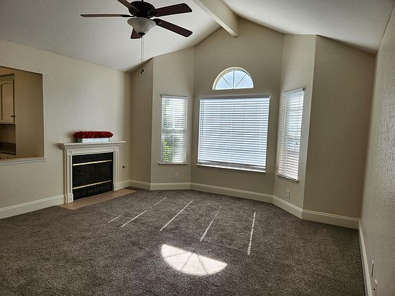 Living room with tall ceilings, large windows, and gas fireplace