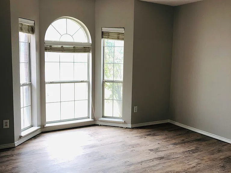 Beautiful front bedroom with arched windows, tons of natural light and beautiful new floors.