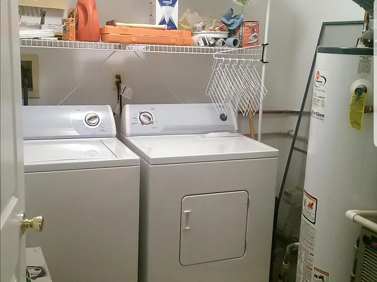 Separate Laundry room with shelves for storage.