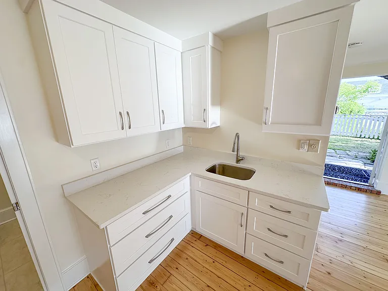 Kitchenette with quartz countertop, wood cabinets, and undermount sink.