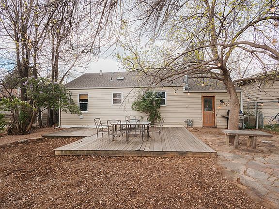 Huge yard with flagstone patio, deck, string lights, and lilacs