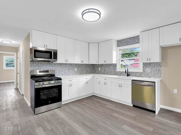 Brand-new kitchen with stainless steel appliances: gas range, microwave, dishwasher, and refrigerator