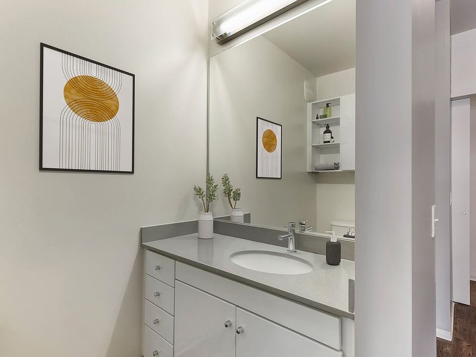 Renovated Package I bath with dark quartz countertops, white cabinetry, and hard surface flooring