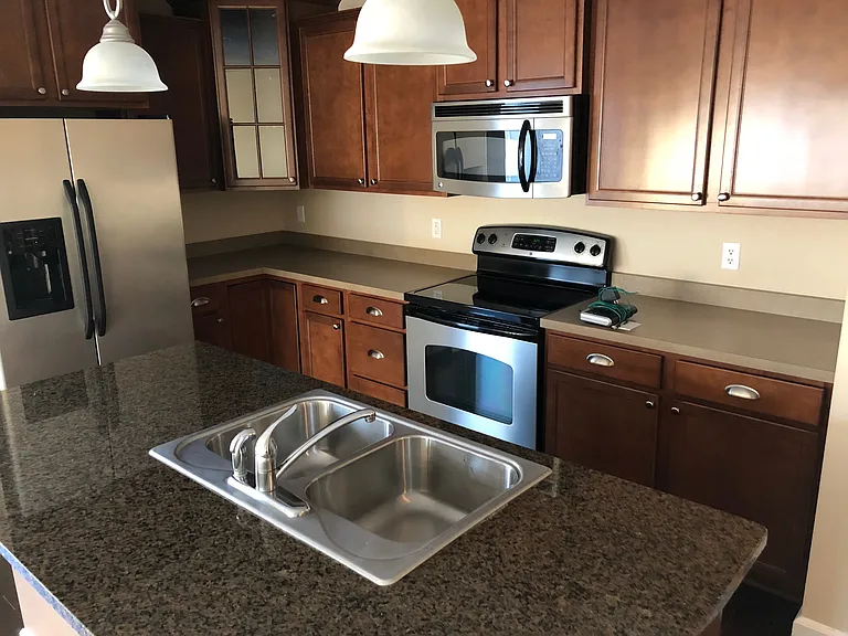 Spacious kitchen with a large island and double sink, offering plenty of counter space for cooking and entertaining.