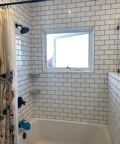 More natural light and shower/bath tub combo with subway tile