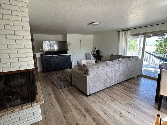 Upstairs living room, dining room, and view of large sliding doors to deck.