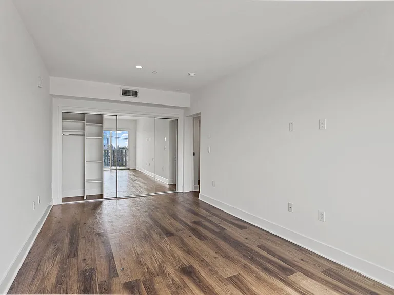 Bedroom with Large-Size Mirrored Closet with Shelving