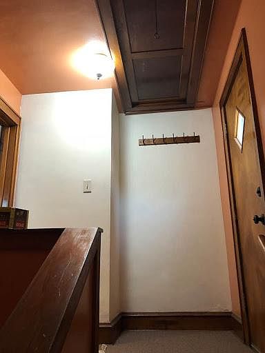 Upstairs back hall with hooks for jackets, etc. Door to right leads to small private balcony; door to left leads to unit.