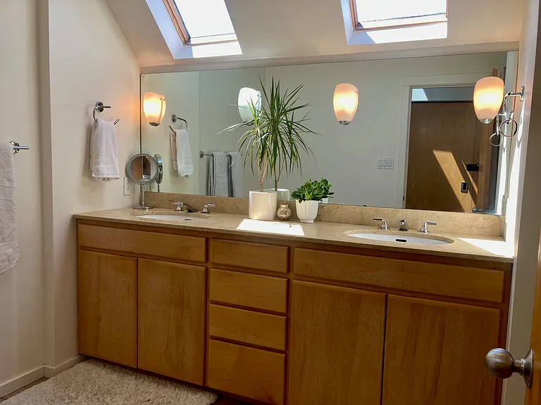 Double sinks, two skylights, bidet, toilet, tub and dual shower heads complete primary bathroom.