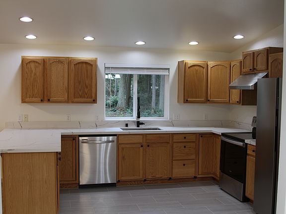 Kitchen from dining area. 
New countertop, fridge, and exhaust hood.