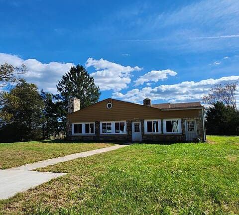 Backside of house leading to basketball court and carport.