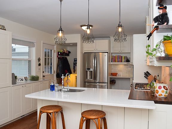 Updated white kitchen with Quartz counters and stainless steel appliances
